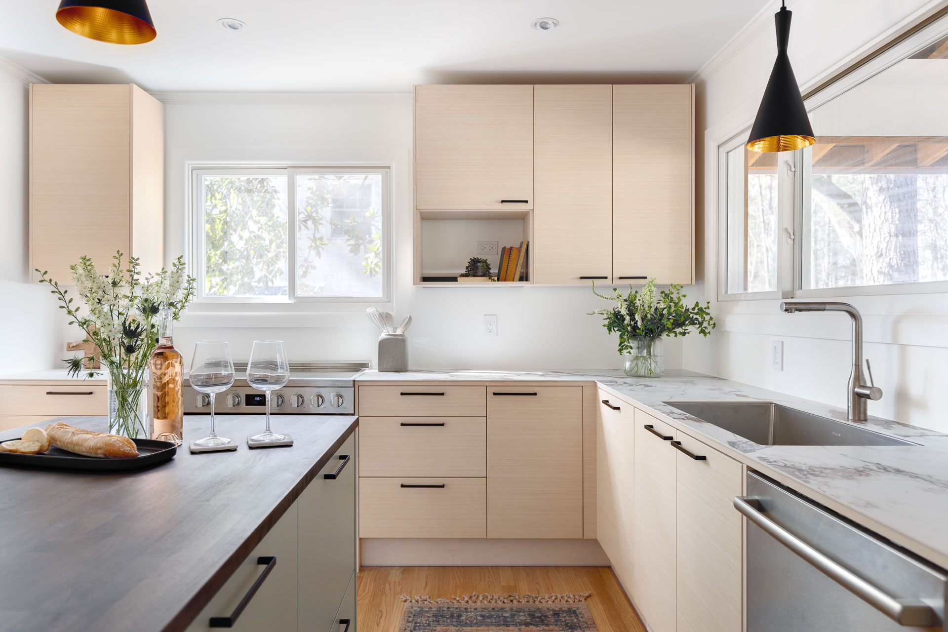 Contemporary light wood kitchen with a silver kitchen faucet and stainless-steel appliances, highlighting interior photography in Durham, North Carolina.